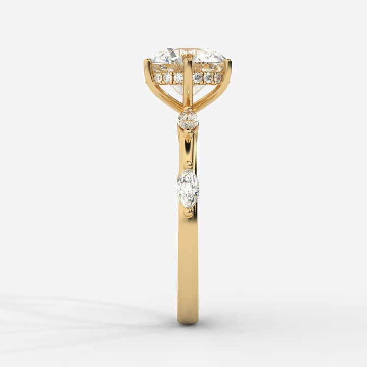 A front view of a gold engagement ring displaying a round lab-grown diamond in a hidden halo setting with marquise-cut lab-grown side diamonds on the band.