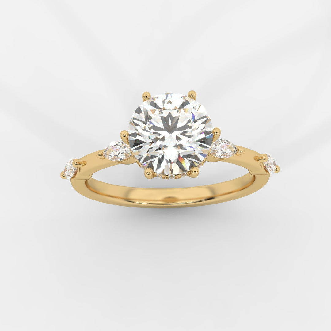 A top view of a gold engagement ring featuring a round-cut lab-grown diamond in a hidden halo setting, with marquise-cut lab-grown side diamonds along the band.